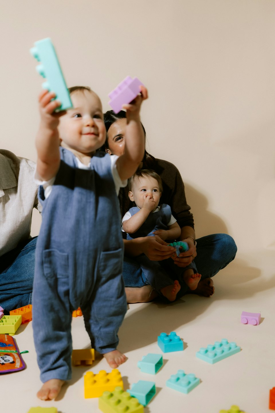 Ouder op de grond met baby bij baby's met blokken.