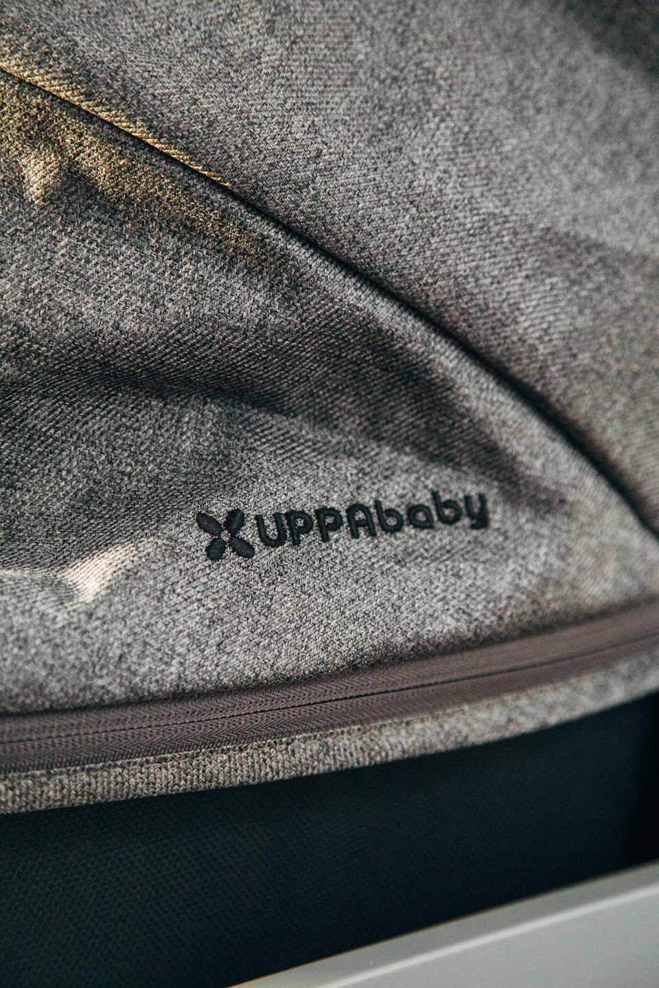 UPPAbaby-logo op grijze stof van kinderwagen.