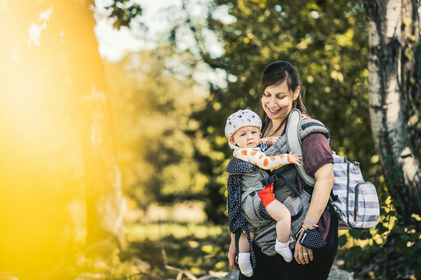 Lachende vrouw met baby buiten.